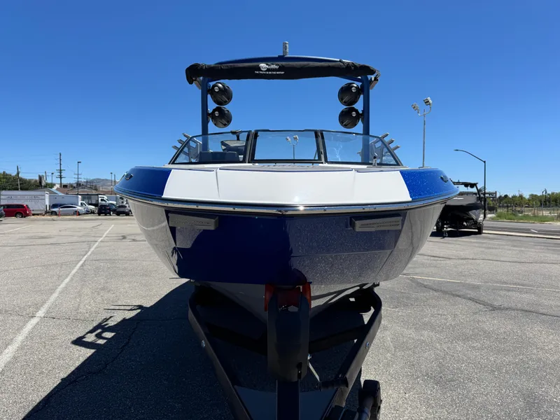 Slide: The Image of 2024 Malibu Wakesetter 23 LSV boat, blue and white, parked on a sunny day. - 3