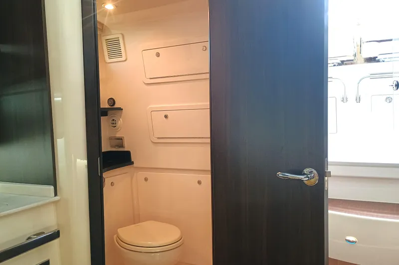 Slide: The Image of 2025 Grady-White Canyon 386 boat interior bathroom with modern fixtures and storage compartments. - 27