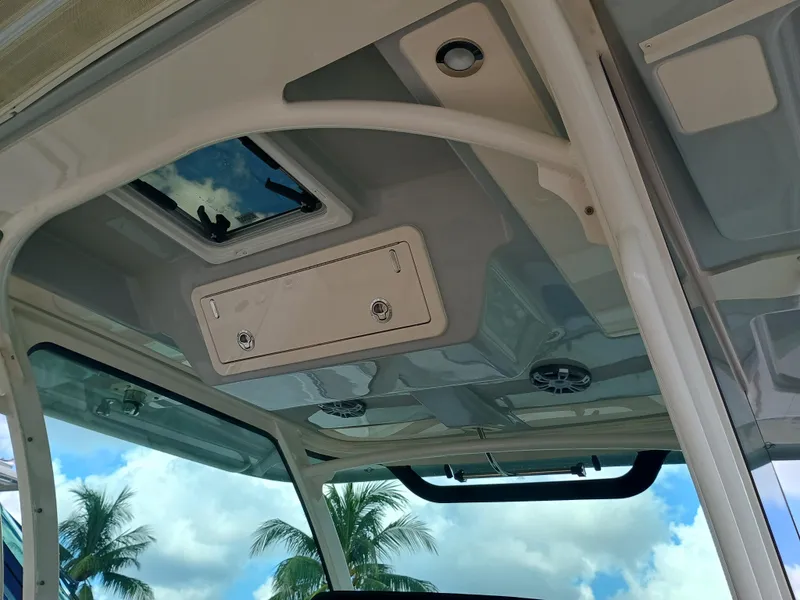 Slide: The Image of 2025 Grady-White Canyon 386 boat interior roof with hatch and speakers, under blue sky. - 35