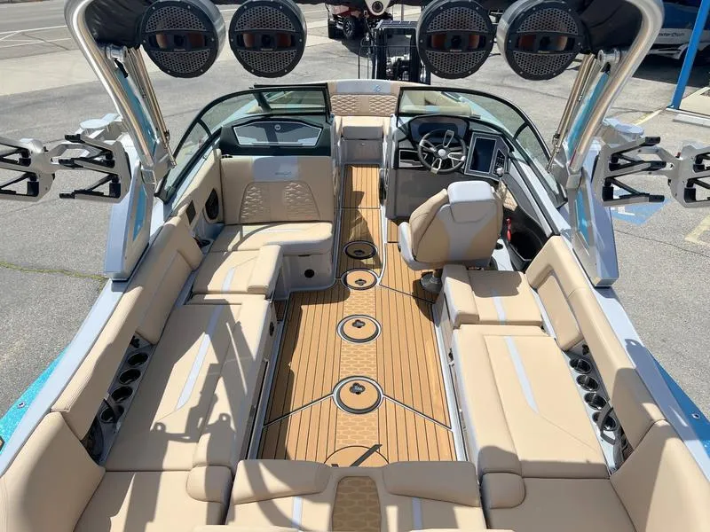 Slide: The Image of 2023 MasterCraft X24 boat interior with beige seating and advanced audio system. - 25