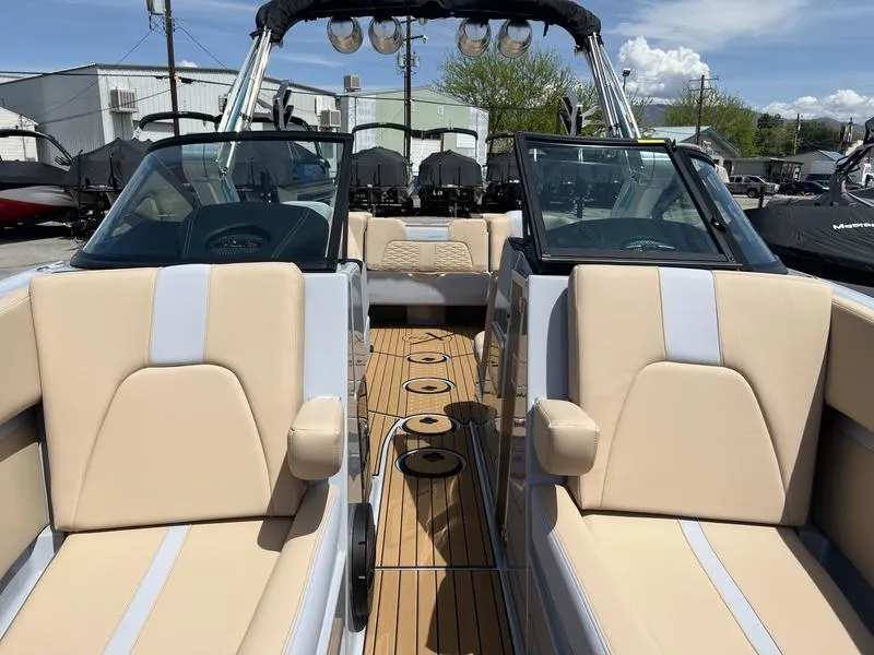 Slide: The Image of 2023 MasterCraft X24 boat interior with beige seating and wooden deck. - 29