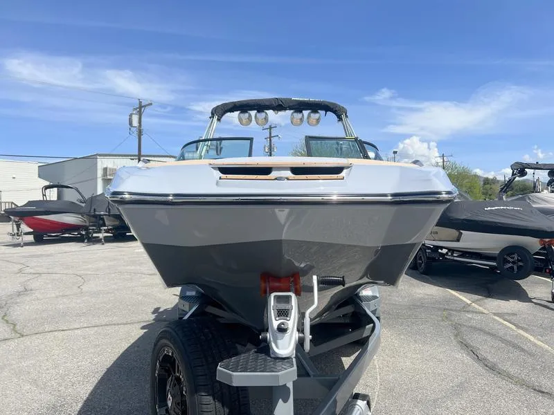 Slide: The Image of 2023 MasterCraft X24 boat on trailer under clear blue sky. - 35