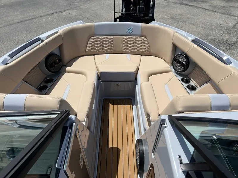 Slide: The Image of 2023 MasterCraft X24 boat interior with beige seating and wood flooring. - 44
