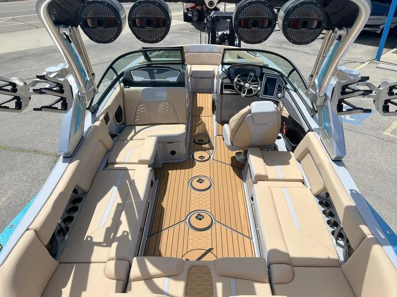Slide: The Image of 2023 MasterCraft X24 boat interior with beige seating and advanced audio system. - 8