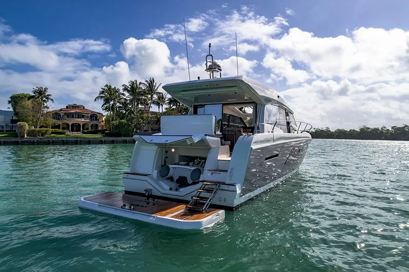 Slide: The Image of 2024 Prestige 520S yacht cruising on a sunny day near a luxurious waterfront property. - 15