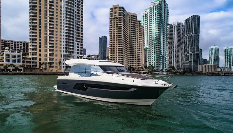 Slide: The Image of 2024 Prestige 520S yacht cruising near city skyscrapers on a sunny day. - 11