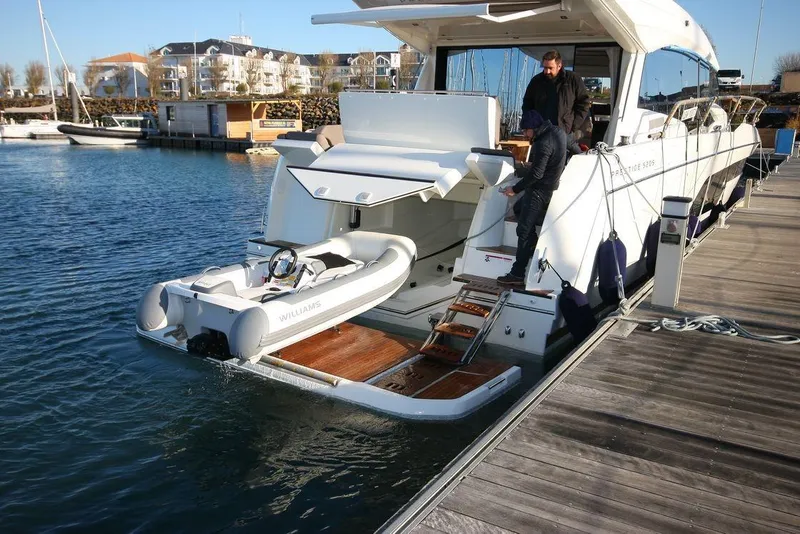 Slide: The Image of 2024 Prestige 520S yacht docked with tender boat and people on deck. - 5