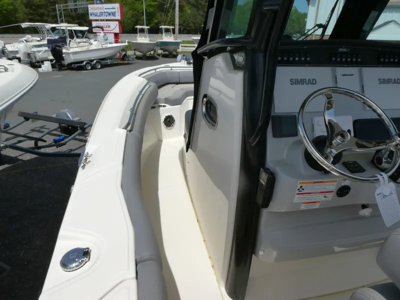 Slide: The Image of 2025 Boston Whaler 250 Outrage boat interior with steering wheel and Simrad electronics. - 11