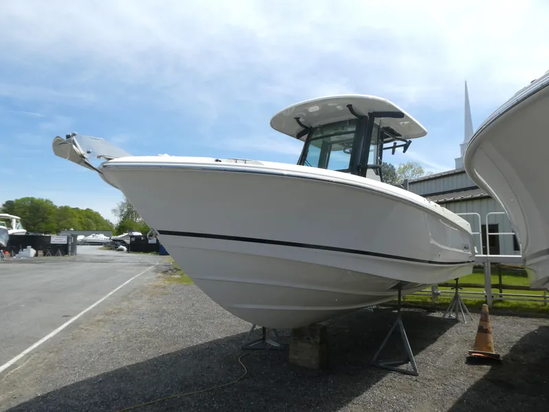 Slide: The Image of 2025 Boston Whaler 250 Outrage boat displayed outdoors on a sunny day. - 2