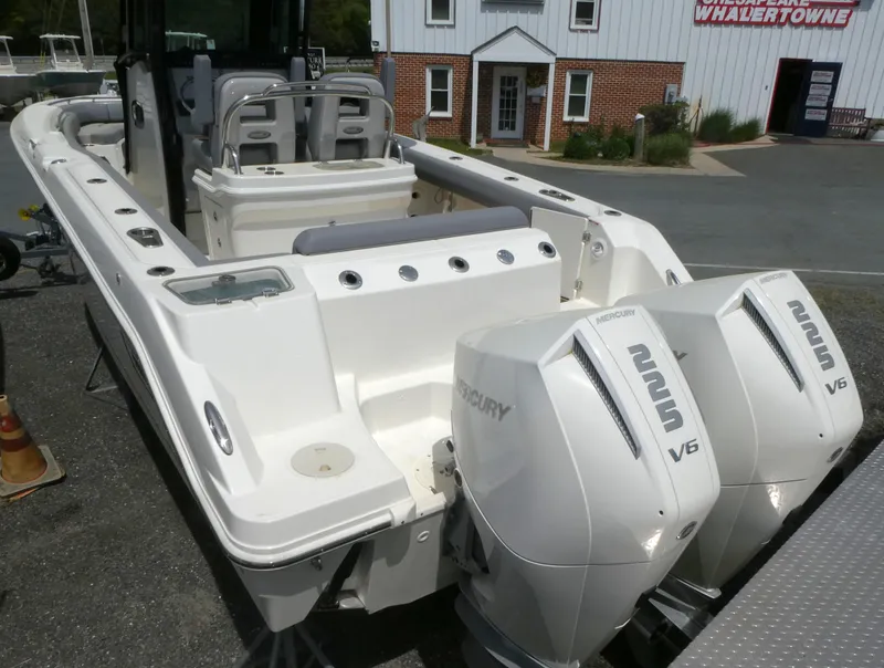 Slide: The Image of 2025 Boston Whaler 250 Outrage with dual Mercury V6 engines, docked near a building. - 3