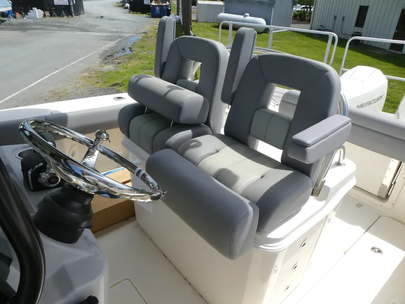 Slide: The Image of 2025 Boston Whaler 250 Outrage boat interior with dual cushioned seats and steering wheel. - 6