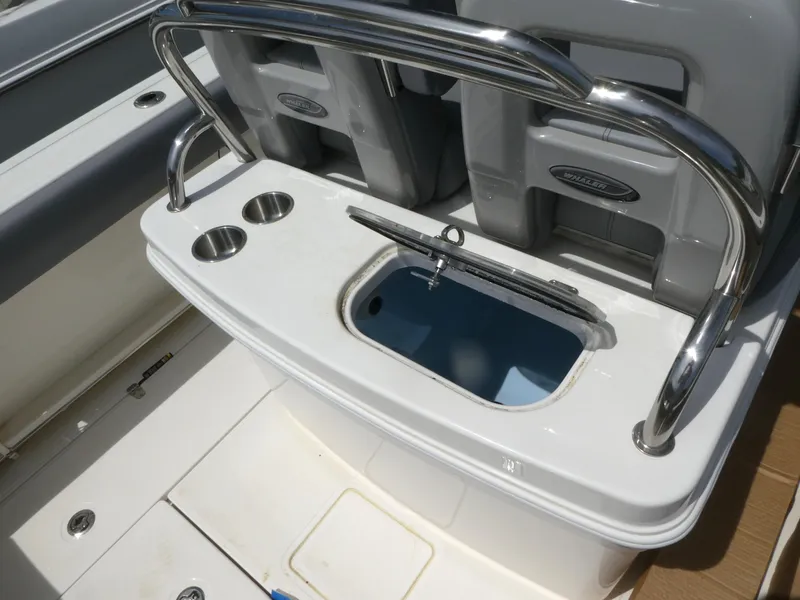 Slide: The Image of 2025 Boston Whaler 250 Outrage boat interior with cup holders and storage compartment. - 7