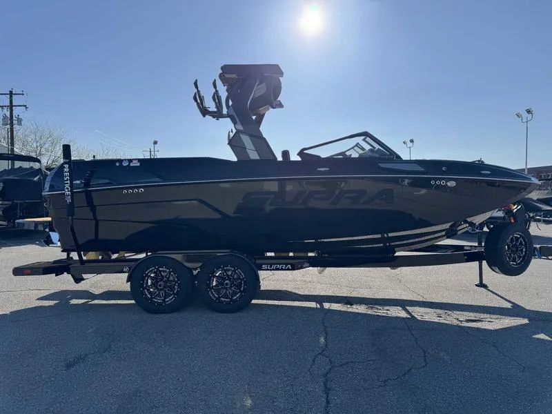 Slide: The Image of 2025 Supra SL boat on trailer under bright sunlight, showcasing sleek design and modern features. - 5