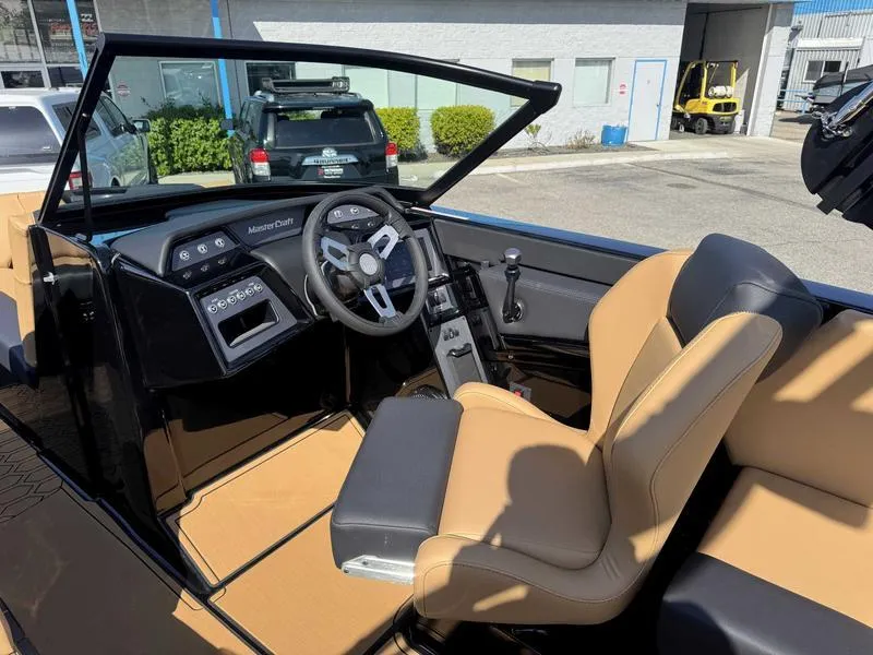 Slide: The Image of 2025 MasterCraft NXT22 boat interior with tan seats and modern dashboard. - 10