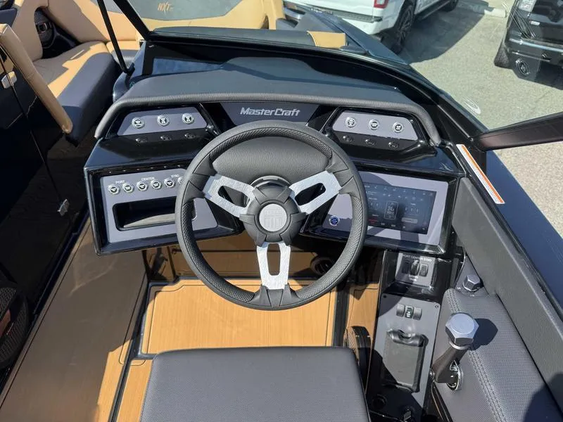 Slide: The Image of 2025 MasterCraft NXT22 boat dashboard with steering wheel and control panel. - 12