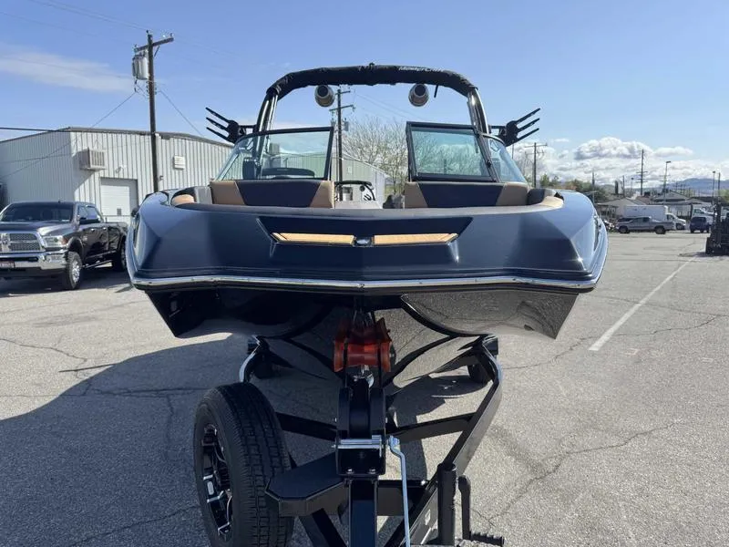 Slide: The Image of 2025 MasterCraft NXT22 boat on trailer, parked outdoors under clear sky. - 3