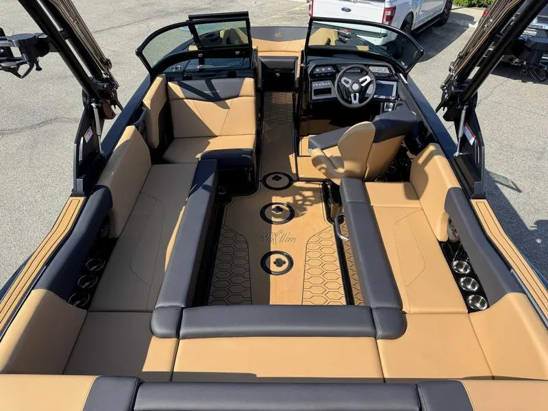 Slide: The Image of 2025 MasterCraft NXT22 boat interior with tan and black seating, modern dashboard, and open layout. - 8