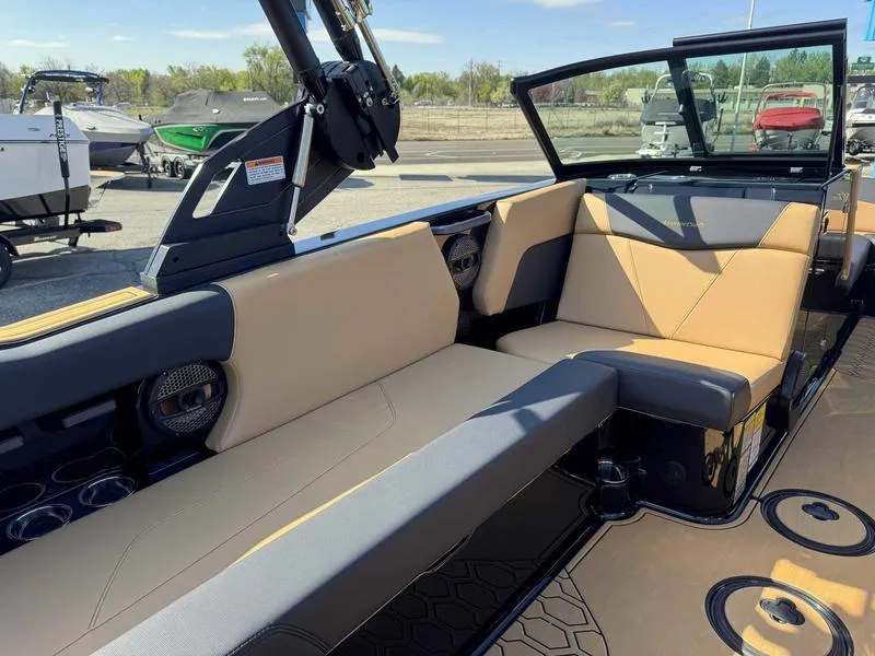 Slide: The Image of 2025 MasterCraft NXT22 boat interior with tan and black seating, modern design. - 9