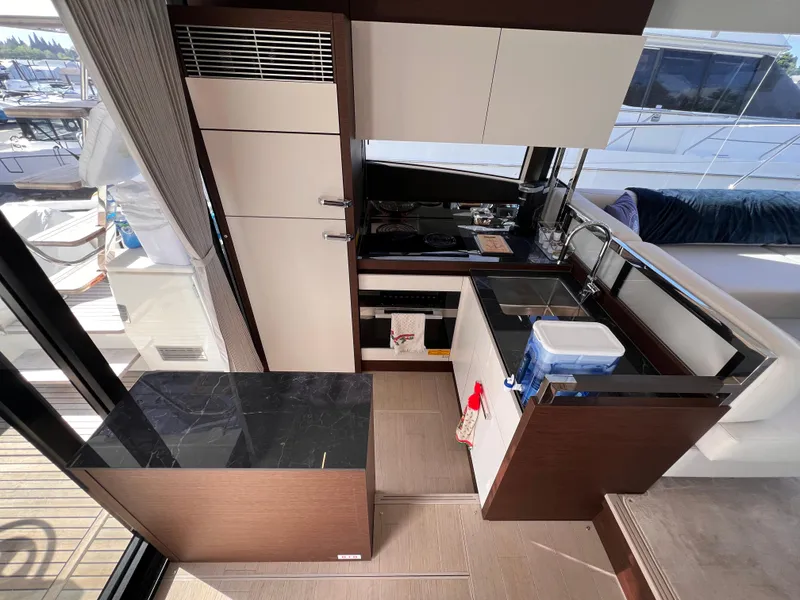 Slide: The Image of Modern kitchen interior on 2023 Prestige 520 yacht, featuring sleek cabinetry and appliances. - 13
