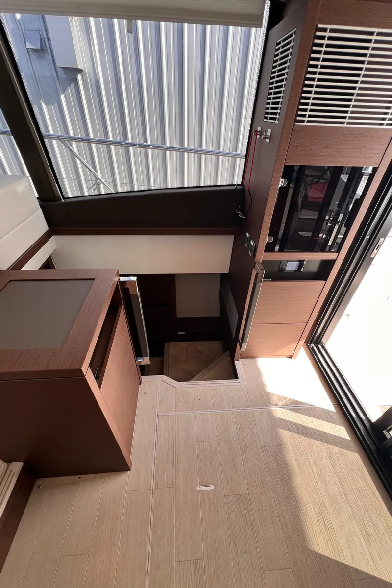 Slide: The Image of Interior view of 2023 Prestige 520 yacht, featuring modern wood finishes and staircase. - 15