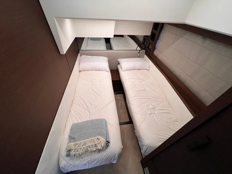Slide: The Image of Twin beds in a 2023 Prestige 520 yacht cabin, featuring modern design and cozy bedding. - 20