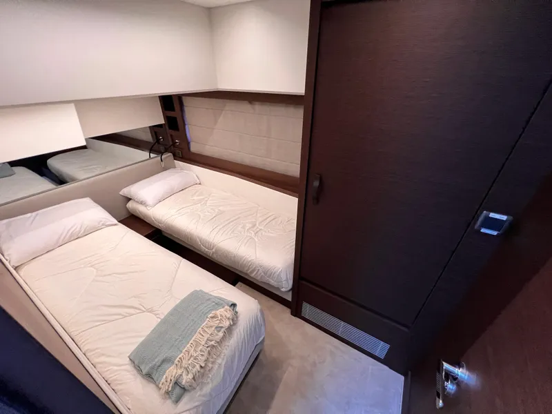 Slide: The Image of 2023 Prestige 520 yacht cabin with twin beds and modern decor. - 21