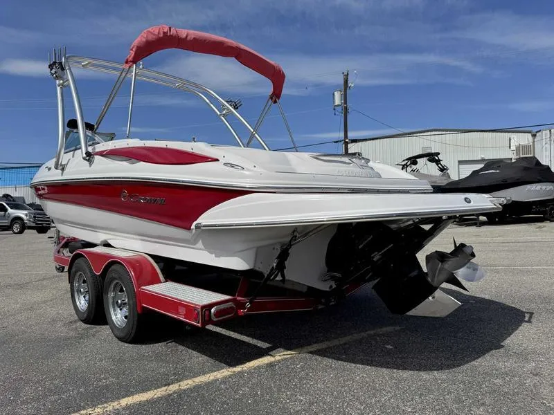 Slide: The Image of 2008 Crownline 230LS boat with red accents on a trailer, parked outdoors. - 4