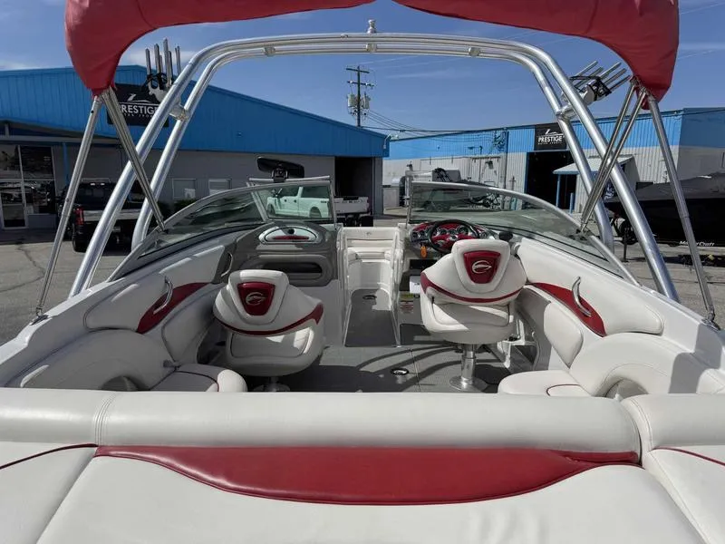 Slide: The Image of 2008 Crownline 230LS boat interior with red and white seating, docked at a marina. - 7