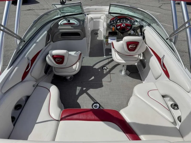 Slide: The Image of 2008 Crownline 230LS boat interior with white and red seating, open cockpit, and steering wheel. - 8