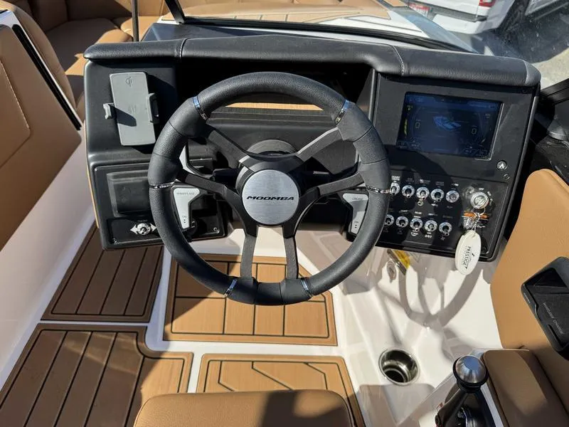 Slide: The Image of 2024 Moomba Max boat dashboard with steering wheel and control panel. - 11