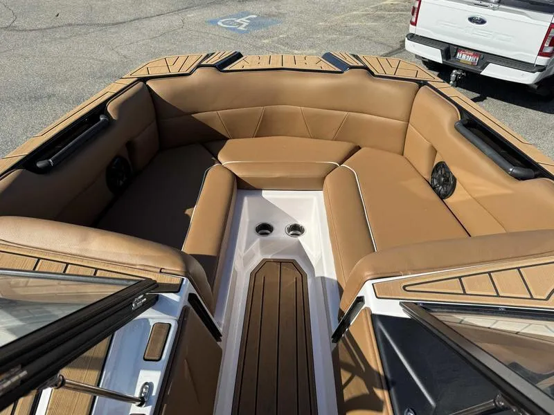 Slide: The Image of 2024 Moomba Max boat interior with tan seating and wood accents. - 12