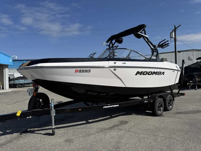 Slide: The Image of 2024 Moomba Max boat on trailer, parked outdoors, showcasing sleek design and modern features. - 2