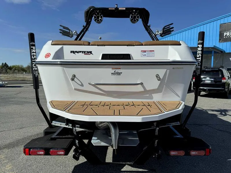 Slide: The Image of 2024 Moomba Max boat rear view with Raptor engine, parked outdoors. - 6