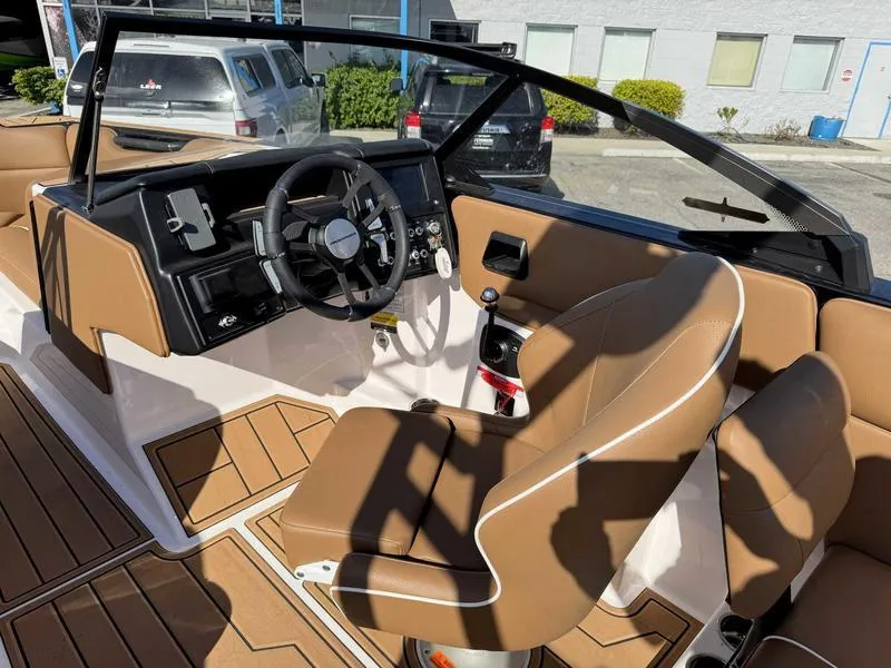 Slide: The Image of 2024 Moomba Max boat interior with brown seating and modern dashboard design. - 9
