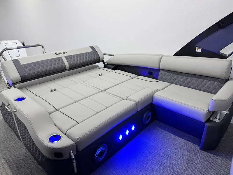 Slide: The Image of 2025 Barletta Reserve Leggera R26UCA boat interior with luxurious seating and ambient blue lighting. - 15