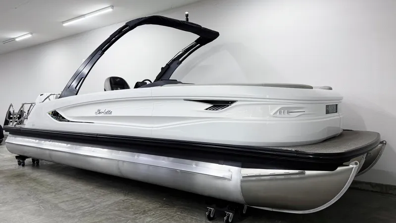 Slide: The Image of 2025 Barletta Reserve Leggera R26UCA pontoon boat in a showroom setting. - 2