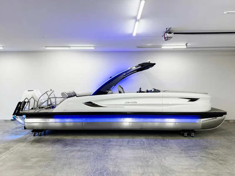 Slide: The Image of 2025 Barletta Reserve Leggera R26UCA pontoon boat with blue LED lights in a showroom. - 4