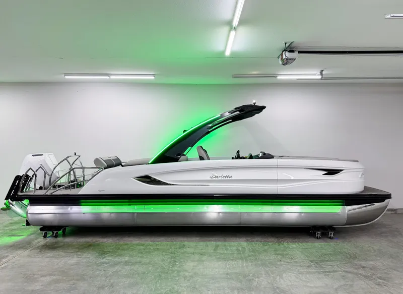 Slide: The Image of 2025 Barletta Reserve Leggera R26UCA pontoon boat with sleek design and green LED lighting. - 5