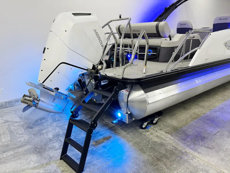 Slide: The Image of 2025 Barletta Reserve Leggera R26UCA pontoon boat with Mercury outboard engine and blue LED lights. - 8