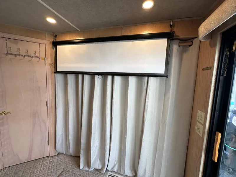 Slide: The Image of Interior of a 1994 Sumerset 16x73 houseboat with curtains and a retractable screen. - 13