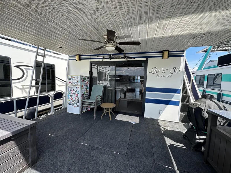 Slide: The Image of 1994 Sumerset 16x73 houseboat deck with seating, ceiling fan, and decorative elements. - 14