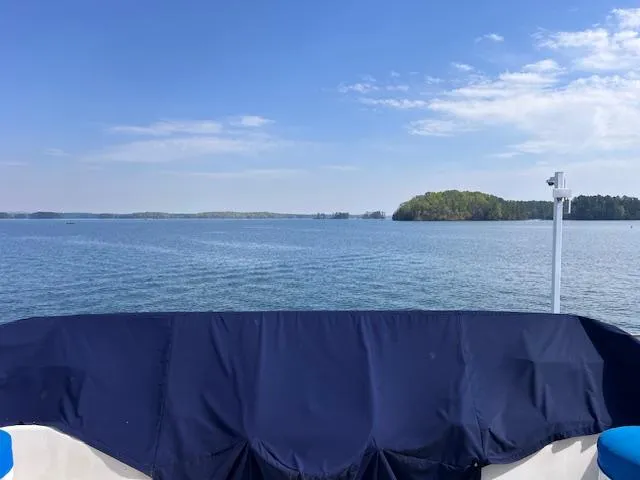 Slide: The Image of 1994 Sumerset 16x73 houseboat on a serene lake with clear blue skies. - 17