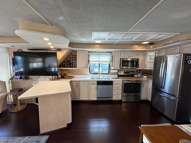 Slide: The Image of Spacious kitchen in a 1994 Sumerset 16x73 houseboat with modern appliances and island counter. - 4