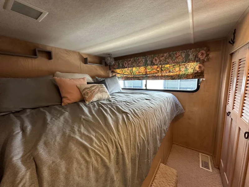 Slide: The Image of Cozy bedroom in a 1994 Sumerset 16x73 houseboat with floral curtains and plush bedding. - 6