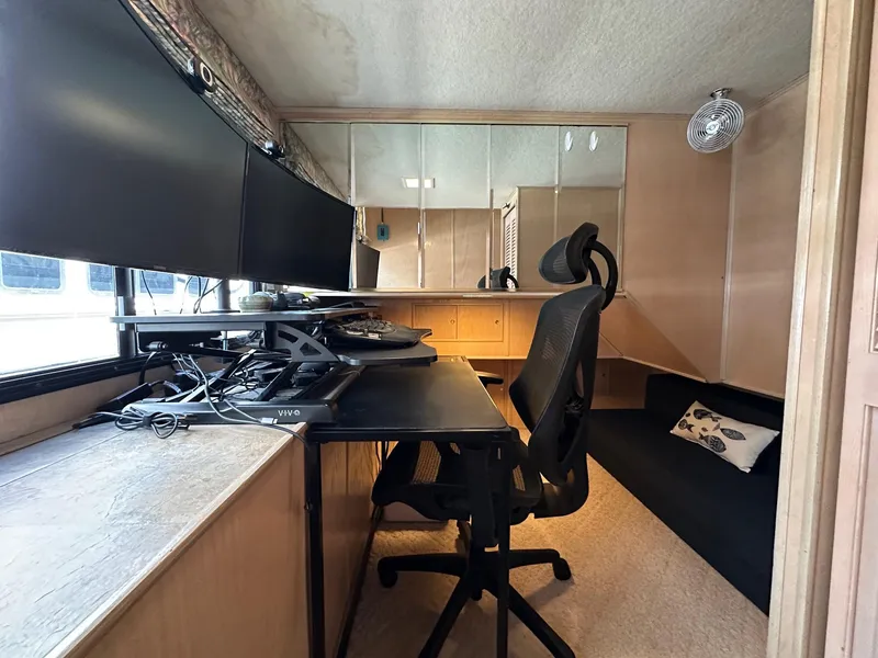 Slide: The Image of Office setup inside a 1994 Sumerset 16x73 houseboat with dual monitors and ergonomic chair. - 8