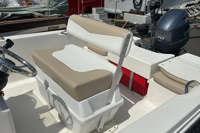 Slide: The Image of 2021 Robalo R160 Center Console boat interior with beige seating and steering wheel. - 22