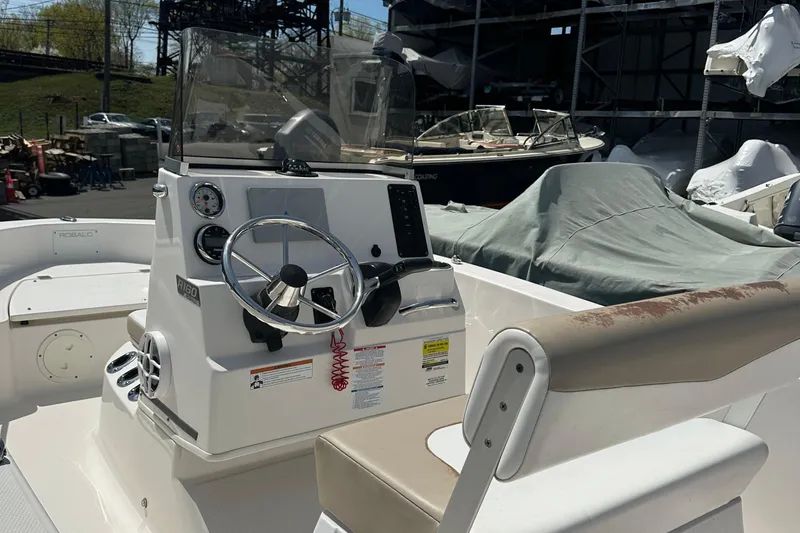 Slide: The Image of 2021 Robalo R160 Center Console boat with steering wheel and control panel. - 24