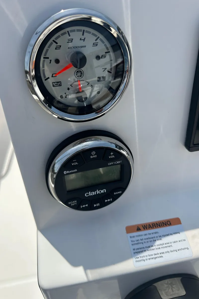 Slide: The Image of 2021 Robalo R160 Center Console dashboard with gauges and Clarion audio system. - 28