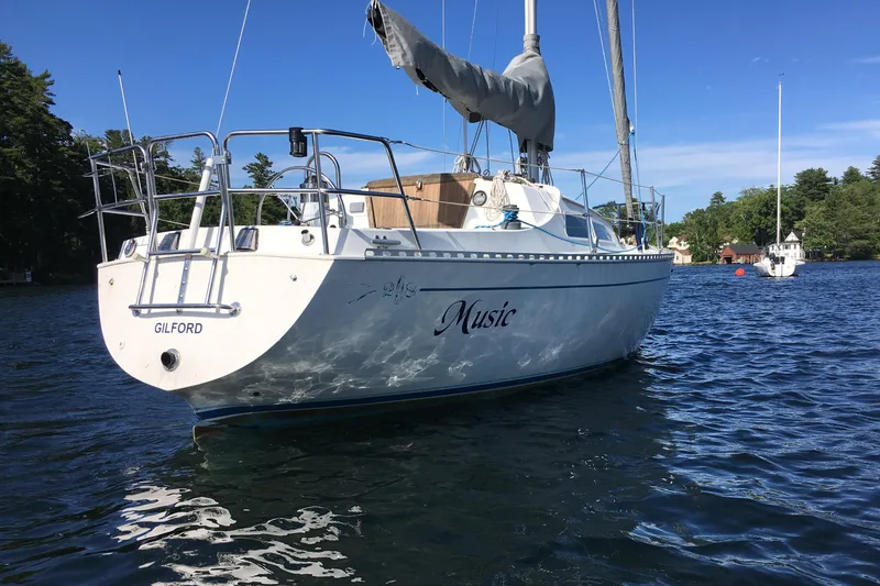 Slide: The Image of 1984 Islander 28 sailboat named "Music" on a serene lake. - 0