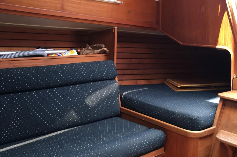 Slide: The Image of Interior of 1984 Islander 28 sailboat with wooden finish and blue upholstered seating. - 15